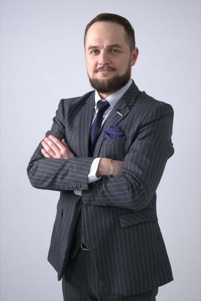 📌 Dicas para quem quer mudar de área profissional (guia completo para fazer a transição com segurança) Professional man with facial hair in a pinstripe suit looking confident and formal.