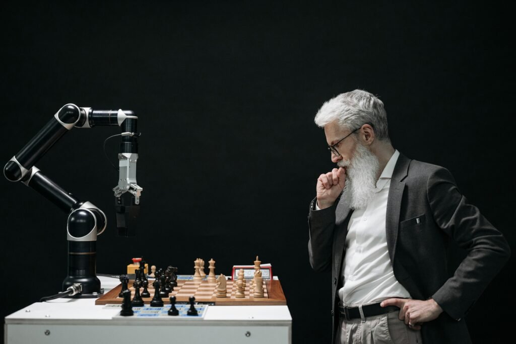 Empregos que Podem Deixar de Existir com a IA e Como se Proteger An elderly scientist contemplates a chess move against a robotic arm on a chessboard.
