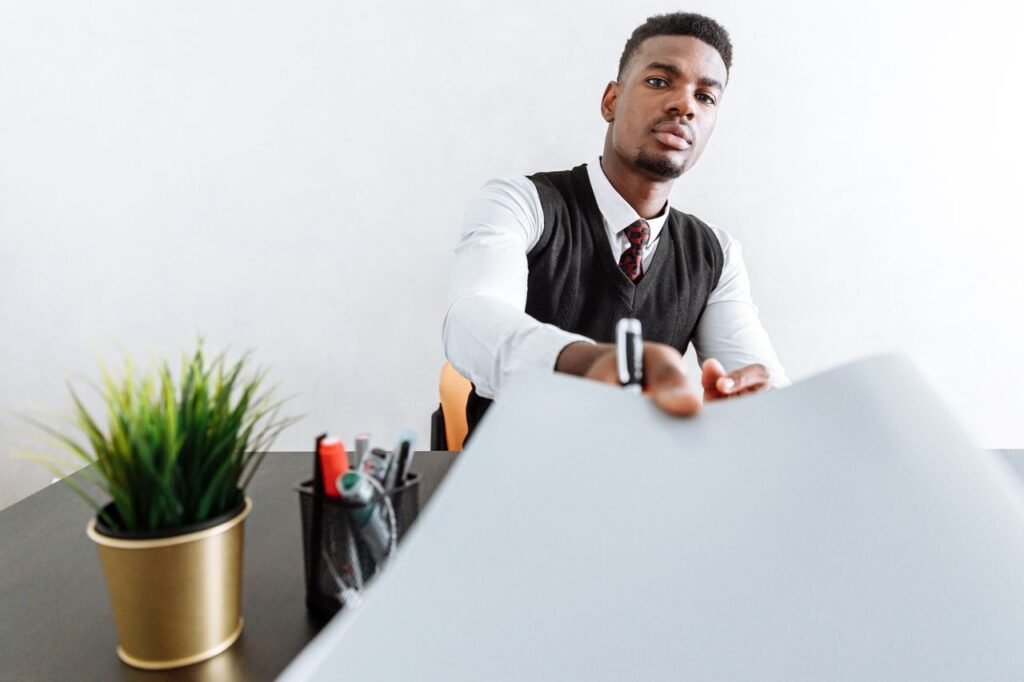 Confident businessman in a suit presenting a document at the office.
