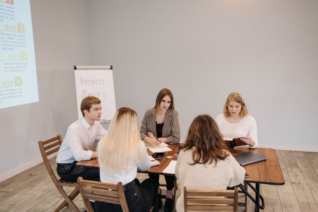 Como se Comportar em uma Dinâmica de Grupo em Processos Seletivos Diverse team engaged in a strategic business meeting at an office setting. Collaborative and focused discussion.